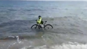 Covid-19, ciclista entra in mare con la sua bici per cercare di evitare il controllo