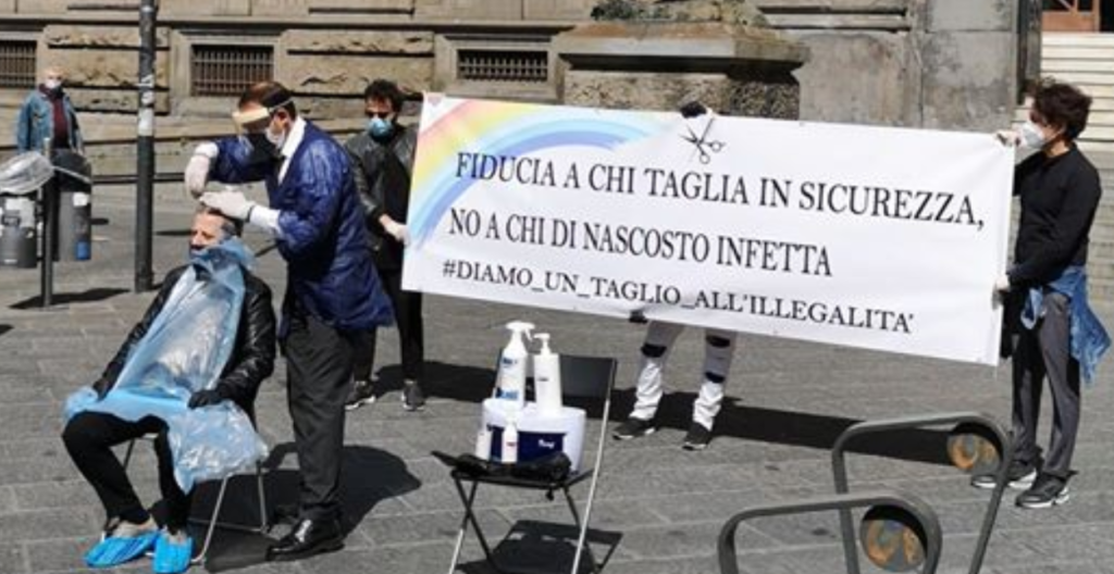 Napoli, parrucchieri e barbieri tagliano capelli in piazza per protesta: lo scatto è virale